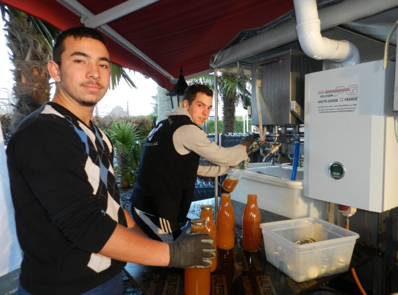 Quentin et Guillaume élèves, en BTS agricole à l’Iseta, mettent en bouteille le jus de pomme (elixir flottin) pasteurisé qui sera vendu sur place et à la tanière des Flottins.